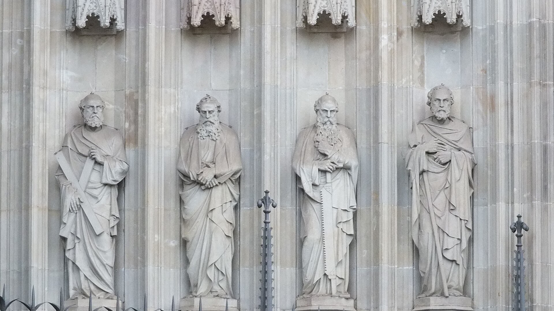 Carved statues of the apostles standing along a cathedral wall